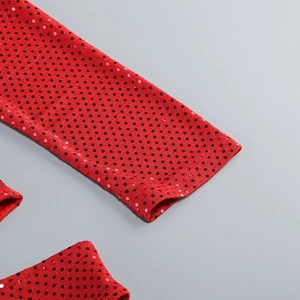 Gros plan sur la texture à paillettes rouges et pois noirs d'une robe longue