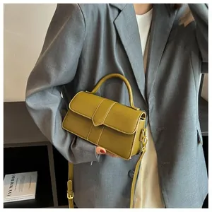 Détail du sac à bandoulière en cuir vert olive avec ferrures dorées et poignée haute
