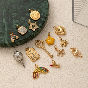 Sortiment an Gold- und Silberanhängern mit Mond-, Herz- und Sternmotiven auf Marmor