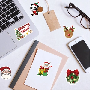 Close-up of colorful Christmas stickers applied to a laptop and smartphone surface