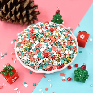 Macro detail of colorful Christmas slime fillers including beads and stars in a pink bowl