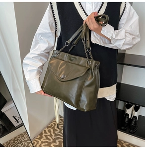 Dettaglio della borsa tote verde oliva scuro con chiusura a scatto e catenella
