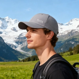 Breathable grey quick-dry baseball cap for men, worn by model in outdoor mountain setting