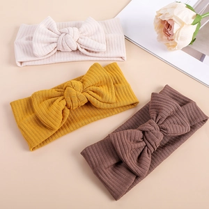 Three-pack of ribbed knit baby headbands with large bows in pink, yellow, and brown