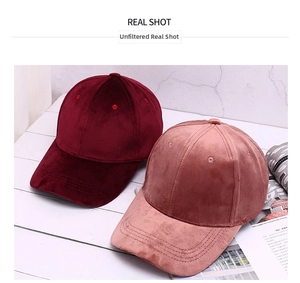 Detail of velvet baseball caps in wine red and soft pink showing plush fabric texture