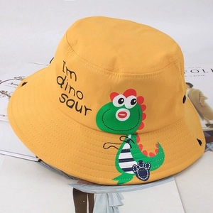 Dettaglio cappello a secchiello giallo bimbi con simpatica stampa di dinosauro verde e ricamo