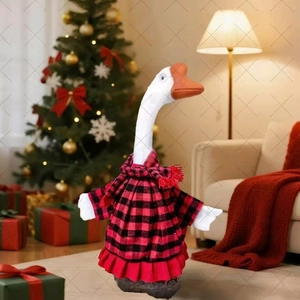 Detail of white goose plush wearing red and black plaid dress by a Christmas tree