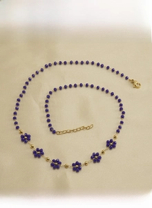 Macro detail of purple crystal beads and gold stainless steel chain with lobster clasp
