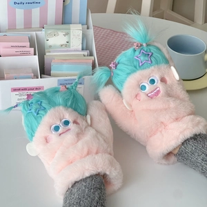 Moufles monstre en peluche rose avec cheveux bleus et pince étoile sur table blanche