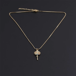 Golden key necklace with colorful gemstone inlay on a professional black background
