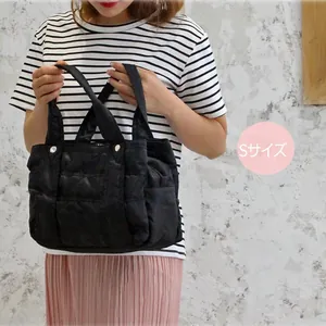 Close-up of small black quilted nylon tote bag with silver buckles and S-size label