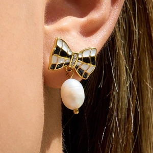 Detail of bow earring with enamel check pattern, crystal center and baroque pearl