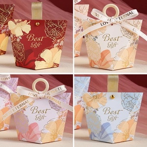 Detail of creative wedding favor boxes in four colors with floral prints and ring handles