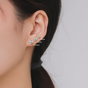 Tre dimensioni di orecchini moissanite in argento 925 sulla orecchio della modella