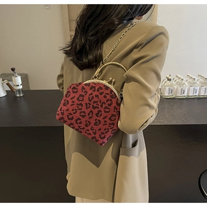 Detail of red leopard print shell bag with vintage gold kiss-lock frame and chain strap
