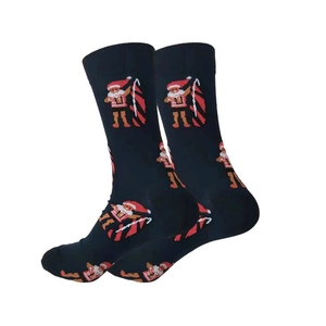 Macro shot of navy blue knit socks featuring gingerbread man festive holiday patterns