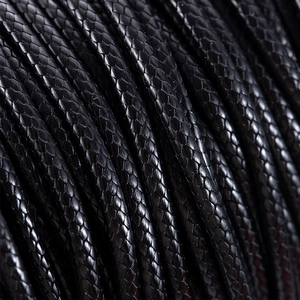 Macro view of black 2.5mm Korean waxed polyester cord with tight braided texture for DIY crafts