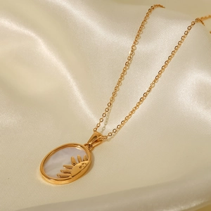 Macro detail of gold sun-shaped pendant with iridescent mother of pearl on silk