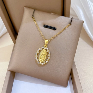 Detailed view of oval Virgin Mary gold pendant with sparkling white marquise gemstones