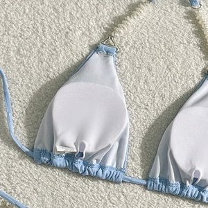 Close-up of light blue bikini top with removable pads and pearl beaded straps detail