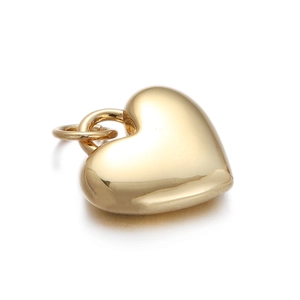 Macro shot of gold-plated heart pendant with religious Virgin Mary engraving detail