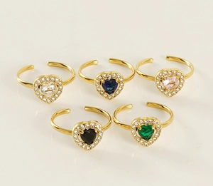 Macro detail of five colorful heart-shaped zircon rings in adjustable golden bands