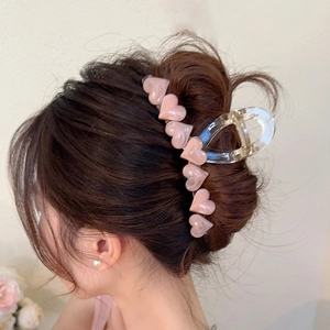 Pink pearlescent heart hair claw clip on dark brown hair with transparent resin base