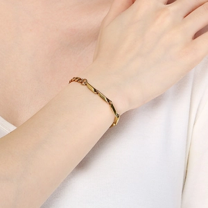 Gold-toned titanium steel Cuban link chain bracelet for men and women on wrist