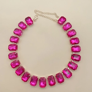 Detail of necklace featuring rectangular pink crystals on a silver chain with lobster clasp
