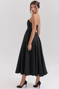 Detail of elegant black strapless satin midi dress with a pleated waist and full A-line skirt