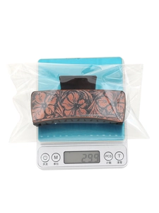 Brown western sunflower hair claw clip on electronic scale showing weight of 29.9g