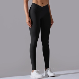 Dettaglio dei pantaloni da yoga senza cuciture con vita a incrocio e tessuto nero traspirante