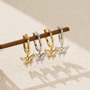 Details von Schmetterlings-Creolen in Gold und Silber mit funkelnden Zirkonia-Steinen