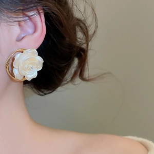 Détail de la boucle d'oreille fleur blanche élégante avec nacre et monture dorée