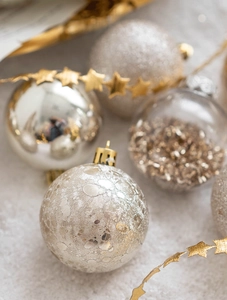 Macro shot of silver and white Christmas ornaments with glitter and cracked textures