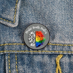 Detailed close-up of a Mental Health Matters enamel pin on a denim jacket