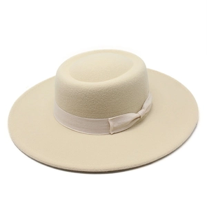 Detailed view of the flat crown and ribbon bow on a cream wool boater hat