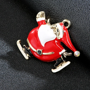 Detail view of a skating Santa Claus brooch with red enamel, gold plating and crystals