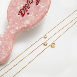 Three-layer gold stainless steel necklace featuring graduated zircon pendants on fine chains