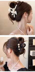 Détail de la pince à cheveux élégante en dentelle et perles portée par un mannequin en noir