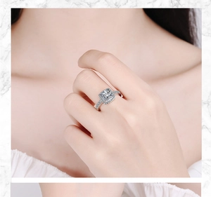Detailed close-up of a cushion-cut halo zircon ring worn on a finger with marble backdrop