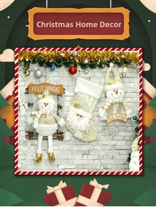 Detailed view of beige and gold knit Christmas stockings with plush snowman and Santa
