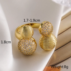 Macro shot of gold geometric ring featuring pave zircon and textured double gourd spheres