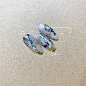 Détail macro de stickers ongles grue avec feuille d'or et décors en coquillage