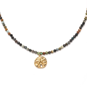 Flat lay view of faceted beaded necklace with golden starfish charm on white background