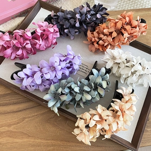 Detailed macro view of multi-colored fabric flower hair clips on a wooden tray