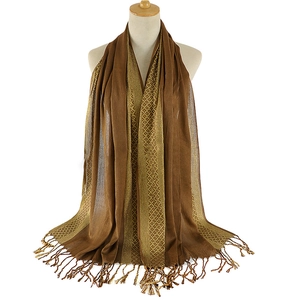 Detailed view of brown shawl scarf featuring gold geometric lines and long fringe trim