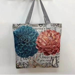 Close-up of floral jacquard canvas bag with blue dahlia patterns and striped straps