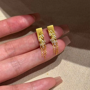 Boucles d'oreilles feuilles dorées avec pompons en zircon et motif épi de blé en main