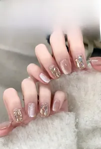 Detail of short cat-eye press-on nails in nude pink with luxury rhinestone accents